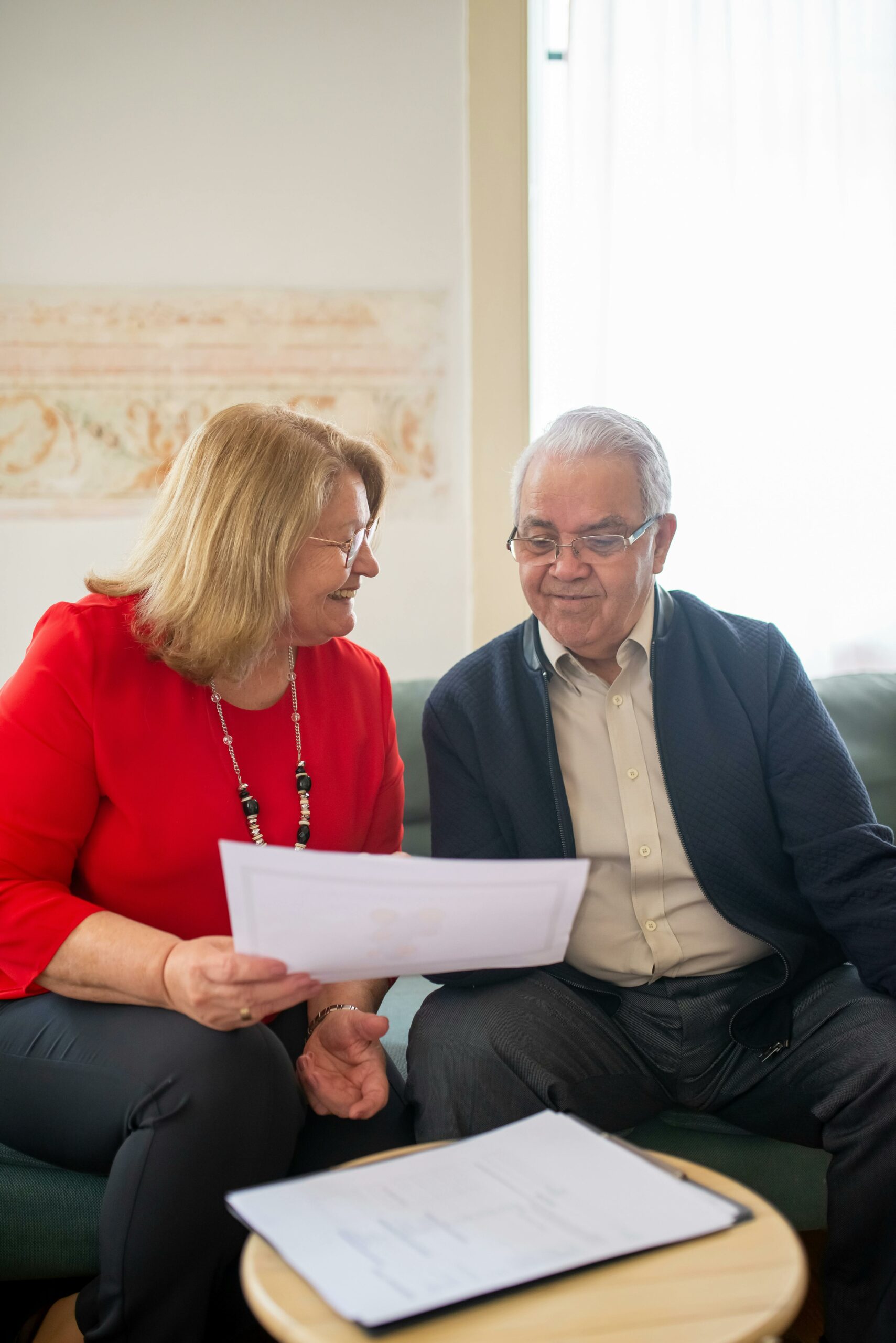 couple assis sur un canapé discutant de l'assurance pension