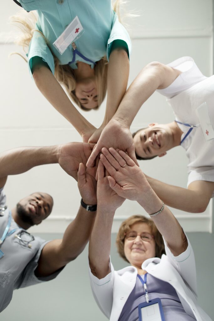 personnel qui ont lais mains les uns au dessus des autres pour célébrer une assurance hospitalisation